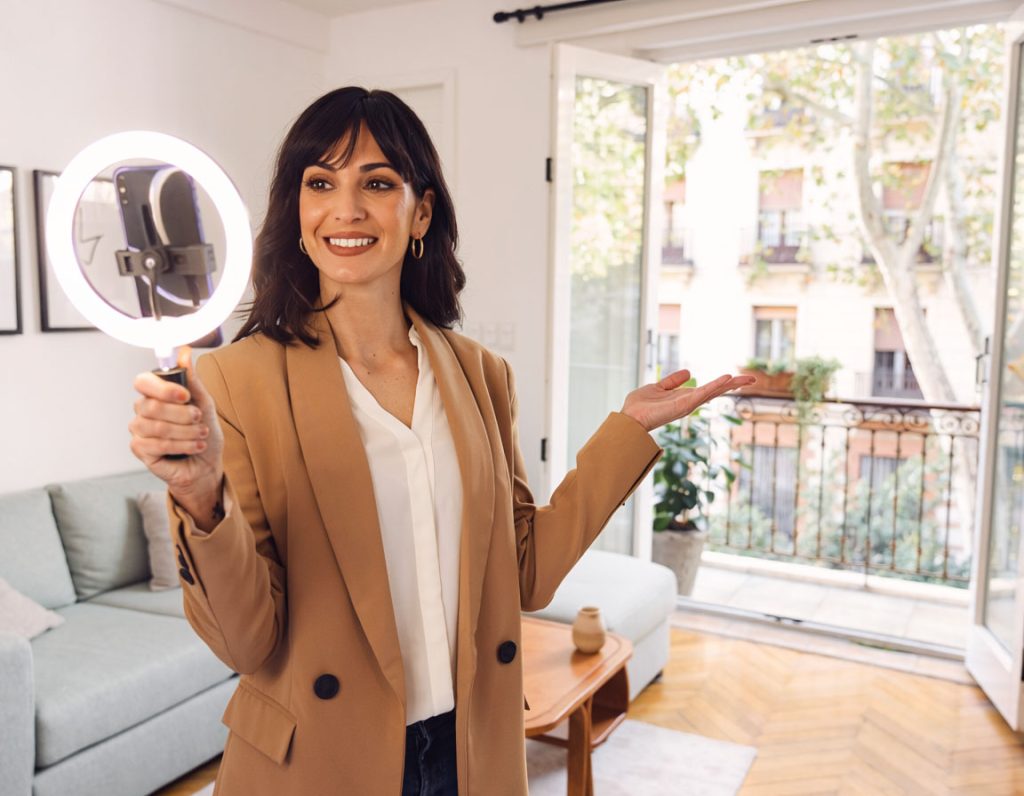 Agente inmobiliario de Madrid grabando un Reel de propiedad para su estrategia de Instagram inmobiliario con smartphone y gimbal